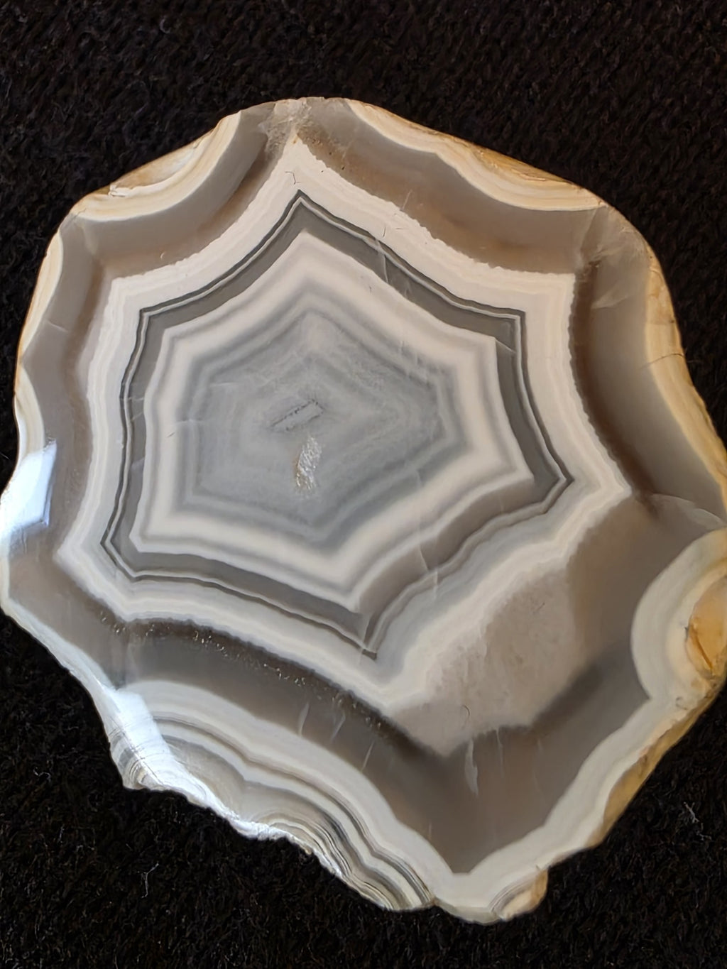Close-up of octagonal concentric banding pattern inside Lebanese banded agate specimen №004, showing sharp chalcedony rings and translucent center.
