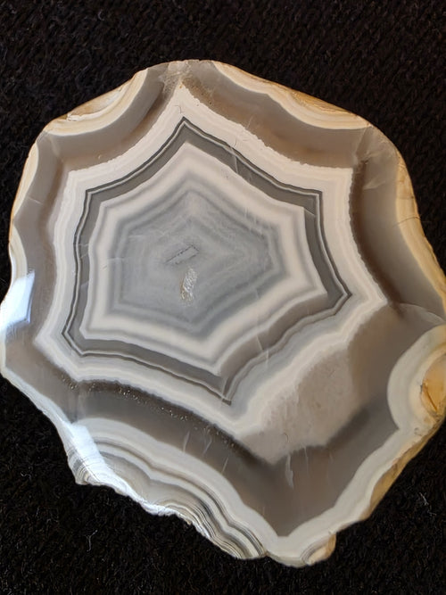 Close-up of octagonal concentric banding pattern inside Lebanese banded agate specimen №004, showing sharp chalcedony rings and translucent center.
