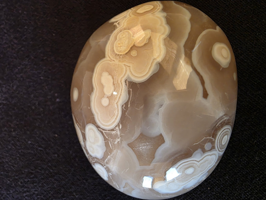 Macro detail of orbicular chalcedony formation in Lebanese agate №003, showing cluster of bullseye patterns and botryoidal inclusions in amber matrix.
