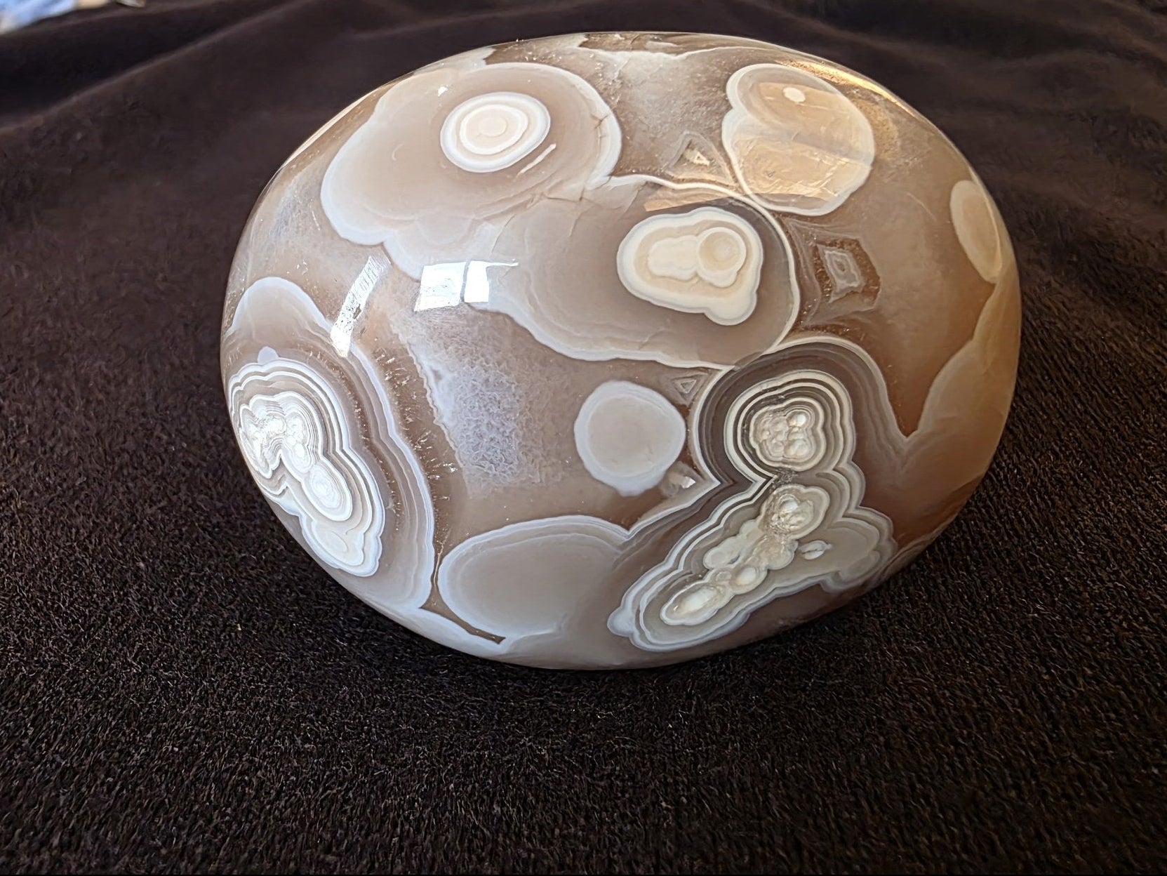 Side profile of hand-polished Lebanese orbicular agate palm stone №003, 4.2 cm tall with rounded dome form, North Lebanon Mediterranean coast origin.
