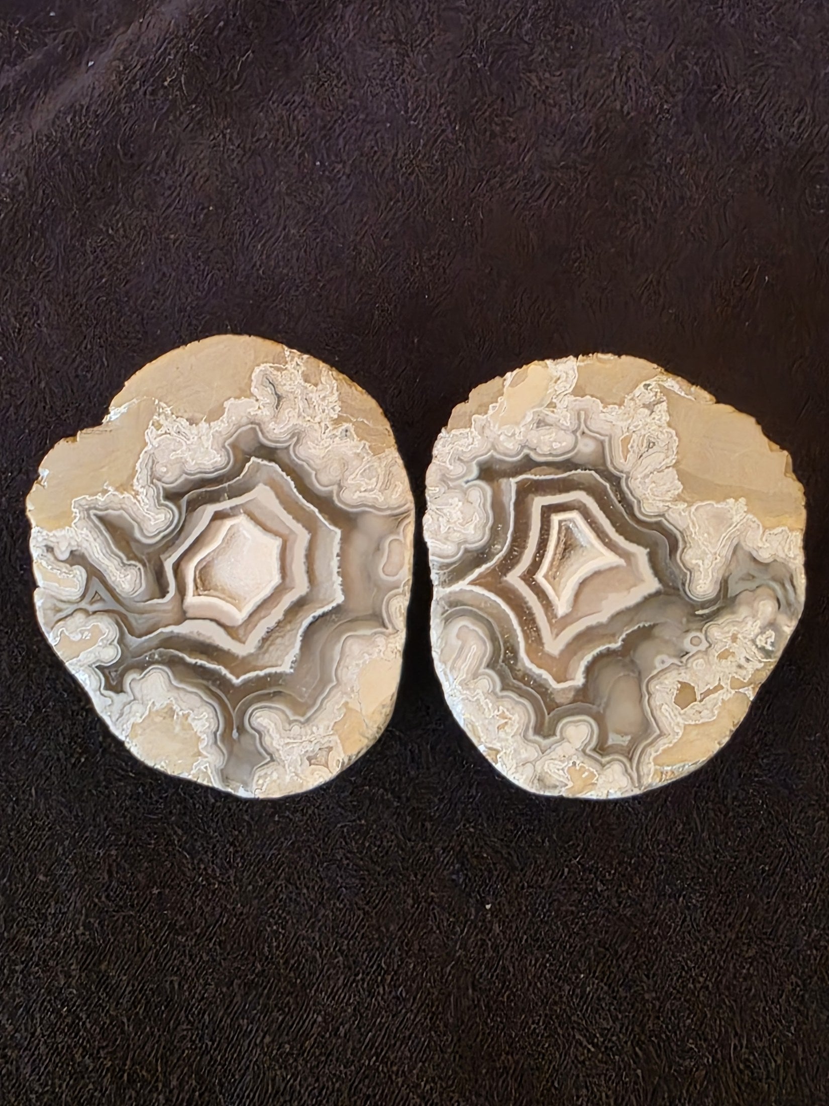 Close-up of both polyhedral agate geode halves showing matched concentric diamond and pentagonal chamber patterns.
